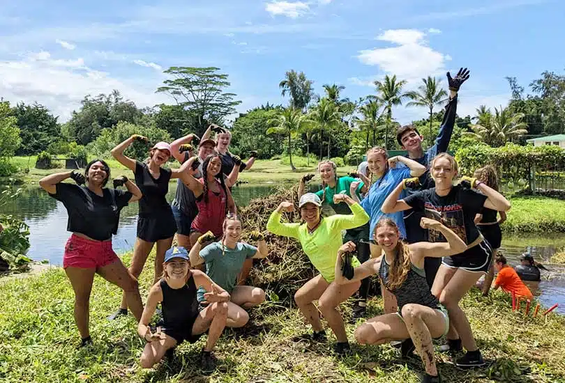 Volunteers working together in Hawaii's lush natural environment as part of Apono Hawaii community service